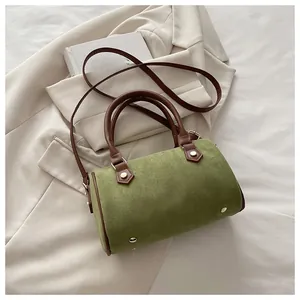 Detailed close-up of olive green matte Boston bag with premium brown leather straps and studs