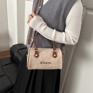 Minimalist beige suede Boston pillow bag with brown leather handles and shoulder strap