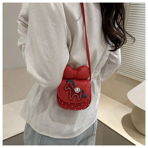 Détail du sac bandoulière rouge avec poney 3D, nœud géant et motif à pois matelassé