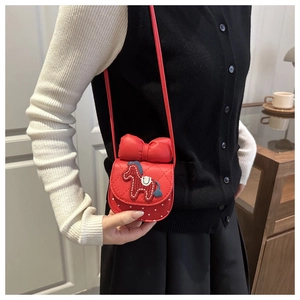 Dettaglio della mini borsa rossa a tracolla con fiocco e ricamo patch a cavallo