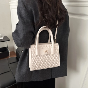 Sac à main élégant en similicuir blanc matelassé avec nœud doré et bandoulière réglable