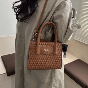 Sac à main matelassé marron foncé avec nœud doré et bandoulière amovible