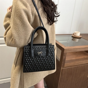 Sac à main matelassé noir chic avec nœud doré et une bandoulière amovible élégante