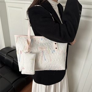 Stylish white quilted tote bag with colorful zigzag stitching and small coin purse charm