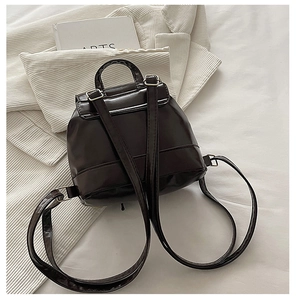 Rear view of deep brown mini backpack with adjustable straps and silver metal hardware
