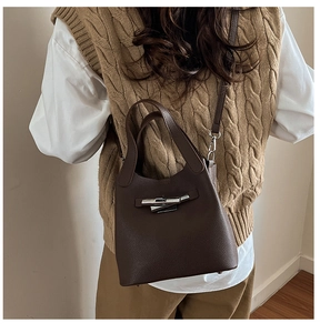 Sac seau en cuir grainé marron foncé porté à l'épaule avec fermoir argenté élégant