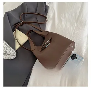 Comparaison de taille détaillée du sac seau en cuir grainé marron foncé et finitions argent