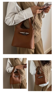 Detail of brown litchi pattern leather bucket bag with silver metal bar lock closure