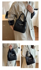 Detail of black leather bucket bag featuring silver twist lock and lychee grain texture