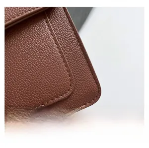 Detail macro shot of high-quality brown lychee grain leather with precise fine stitching