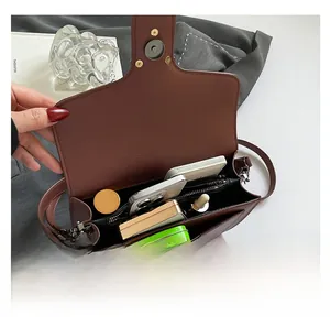 Detail view of the spacious interior of a brown leather crossbody bag with compartments