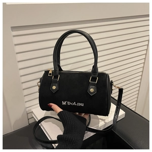 Detail of black matte Boston bag with leather handles and white embroidered branding