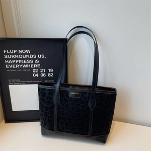Minimalist black leopard print tote bag with leather straps and golden brand logo