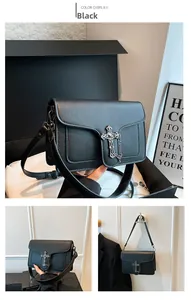 Detail of black pebbled leather crossbody bag with vintage silver cross metal buckle