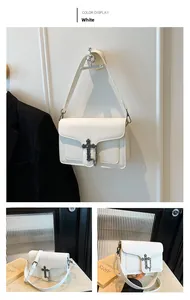 Detail of white lychee leather texture and vintage cross clasp with metal chain on the bag