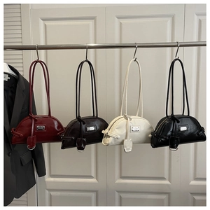Detailed close-up of glossy half-moon bowling bags in burgundy, coffee, white and black colors