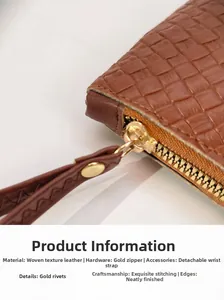 Close-up of brown woven leather clutch with gold zipper and detachable wrist strap