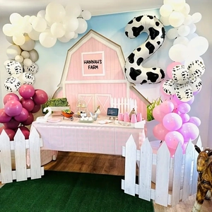 Pink farm theme 2nd birthday party set with cow print balloons and barn backdrop