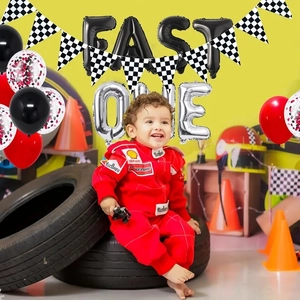Racing themed first birthday party set with FAST ONE balloons and checkered flags