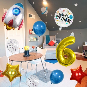 Space theme party decor with rocket balloons and a golden number 6 for 6th birthday
