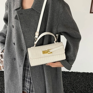 Chique beige handtas met krokodillentextuur, goudkleurige draaisluiting en schouderriem