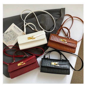 Detail view of woven leather texture and gold twist lock on stylish rectangle handbags