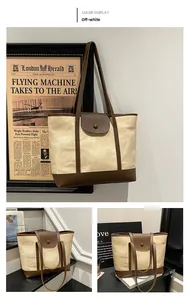 Close-up of contrast beige canvas tote bag with brown leather details and vintage aesthetic