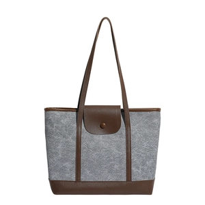 Minimalist grey felt tote bag with brown leather handles and buckle in front view