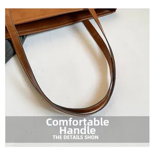 Detail view of brown leather tote with embossed logo patterns and durable handles