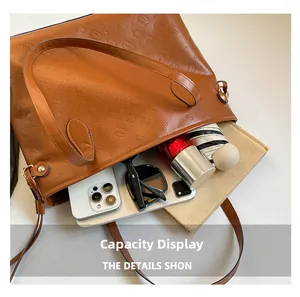 Interior view showing the large capacity of the embossed brown tote bag with daily items