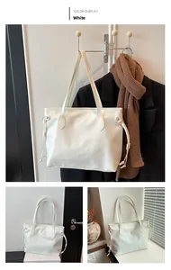 Close-up of white tote bag featuring embossed cartoon patterns and drawstring side detail