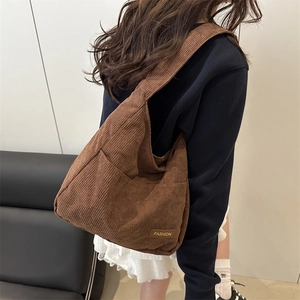Brown corduroy shoulder bag with large capacity and fashion label on model