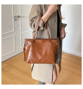 Detailed view of caramel brown embossed tote bag with cartoon animal patterns and side laces