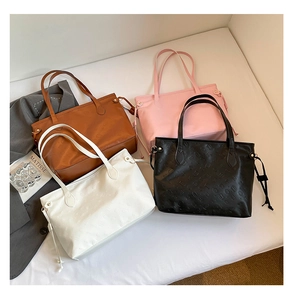 Detailed overhead view of assorted embossed tote bags in brown, pink, white, and black colors