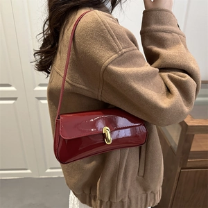 Chic burgundy patent leather baguette shoulder bag with gold rotating capsule buckle