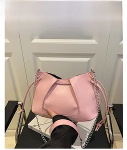 Detailed close-up of pink pleated leather tote with silver chain strap and drawstring