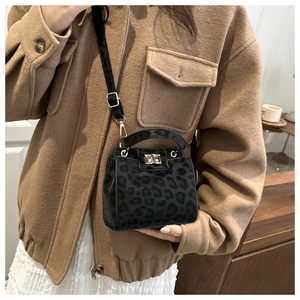 Detailed close-up of leopard print crossbody bag with gold twist lock and matte finish