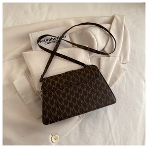Close-up of the vintage brown crossbody bag with all-over M-letter monogram print