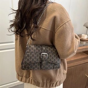 Sac bandoulière marron vintage avec imprimé lettres et chaîne argentée sur mannequin