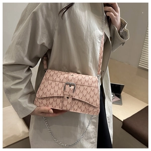 Gros plan détaillé du sac rose avec imprimé M et bandoulière en chaîne argentée