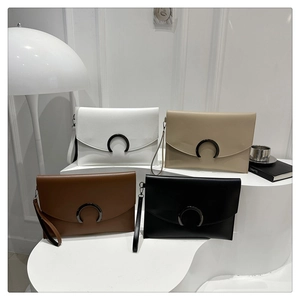 Detail of elegant envelope clutches with crescent buckles in white, khaki, brown, and black