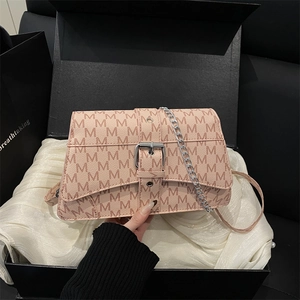 Pink monogram shoulder bag with silver chain on elegant white satin gift box background
