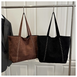Detail of vintage large tote bags in brown and black with silver rivet studs
