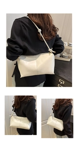 Detail of off-white faux leather tote bag showing vertical stitching and knot shoulder strap