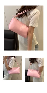 Detail of pink faux leather shoulder bag featuring decorative knotted strap and zipper