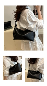 Detail view of a black leather shoulder bag featuring a unique knotted strap design