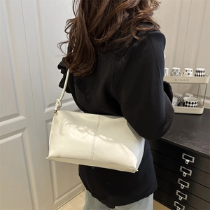 Minimalist beige tote bag for women with stitch details and twisted shoulder strap design