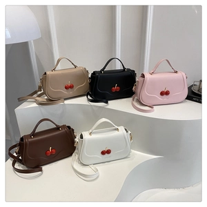 Collection of small crossbody bags with cherry clasps in five colors on a white display stand