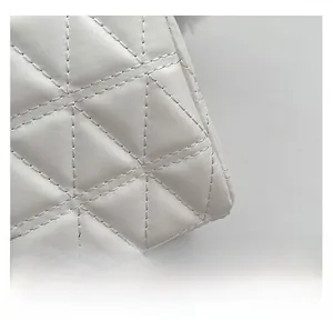 Vue macro de la texture matelassée blanche avec coutures détaillées en losanges