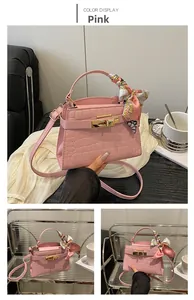 Pink croc-embossed handbag featuring a gold twist lock and silk scarf wrapped handle